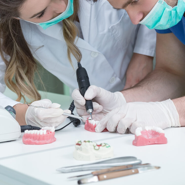 a dentist and lab technician making denture adjustments