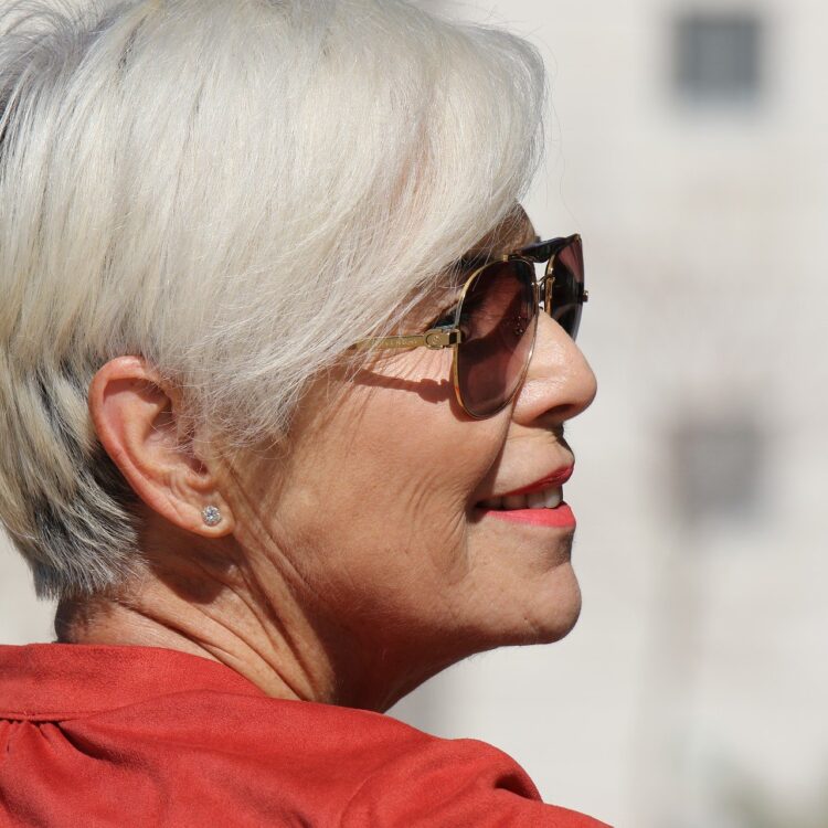 an elderly woman showing off her beautiful smile with an affordable denture
